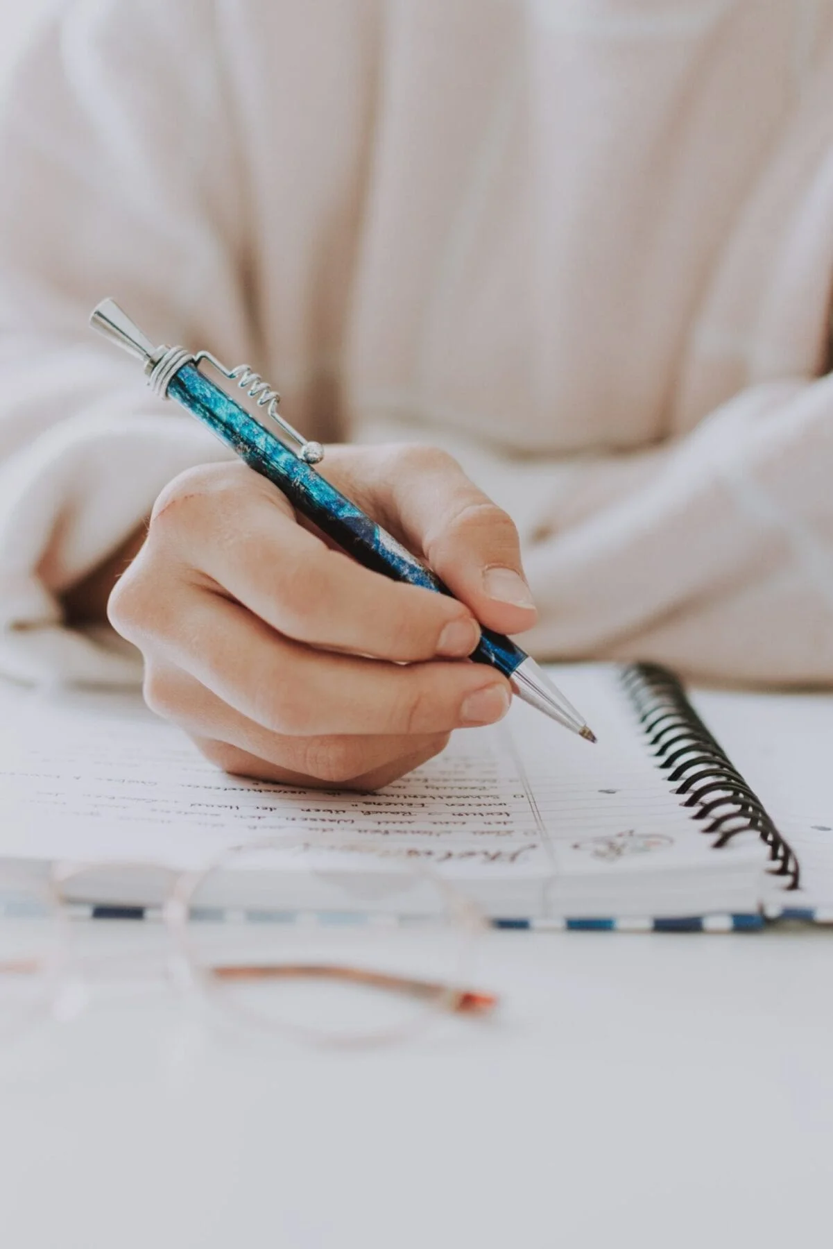Woman with pen writing notes in notepad