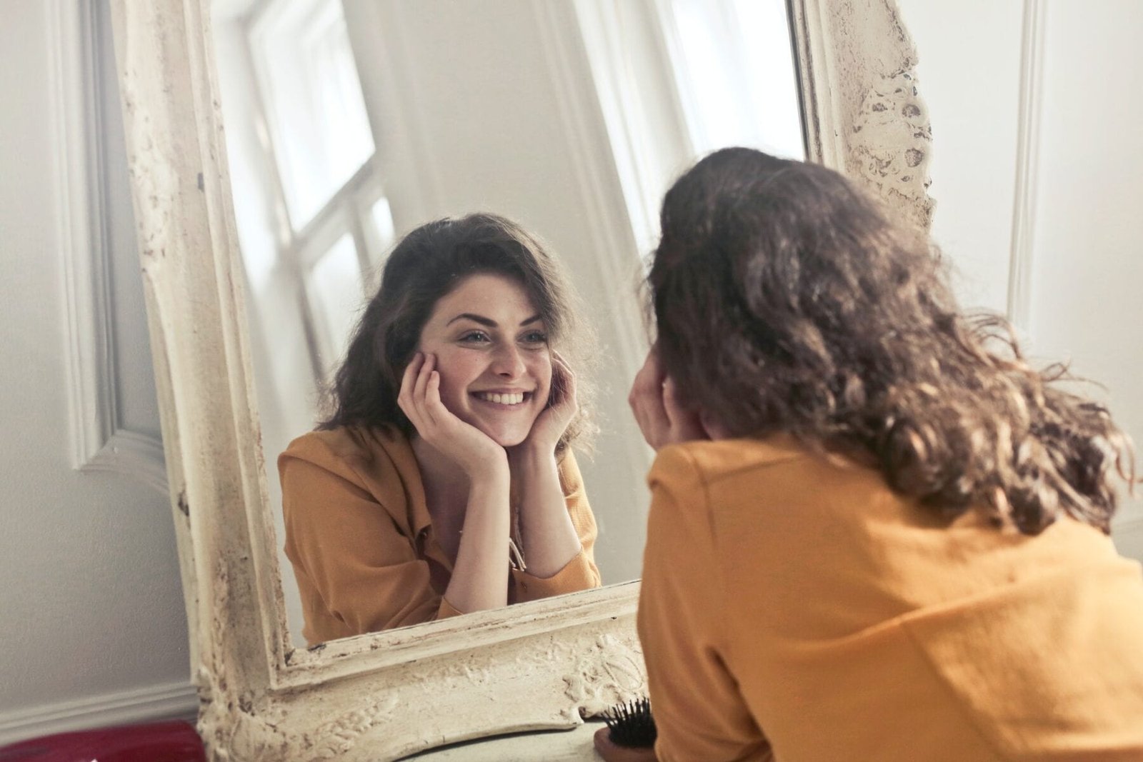 Photo of Woman Looking at the Mirror and Saying Affirmations