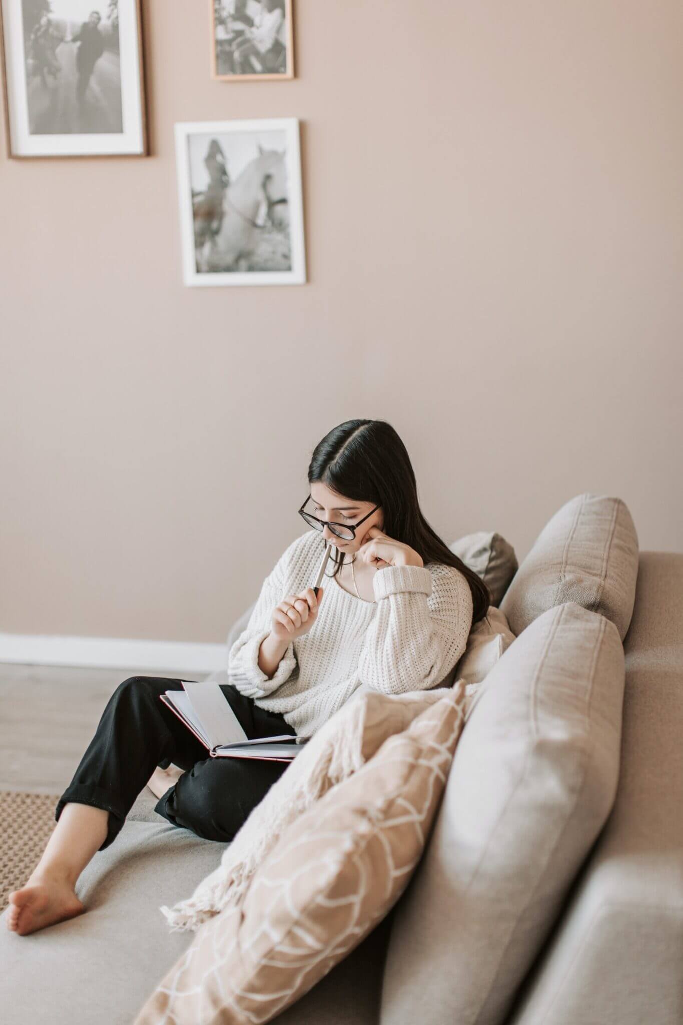 girl journaling on a white sofa