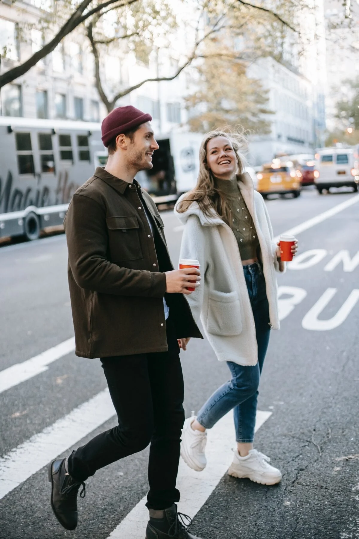 Couple walking on street with coffee cups